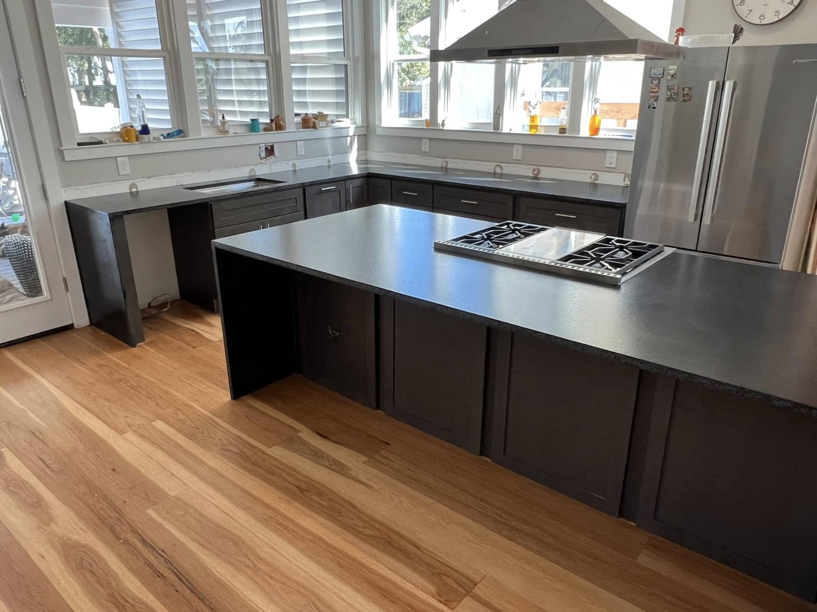Dark countertop kitchen with large island and natural light